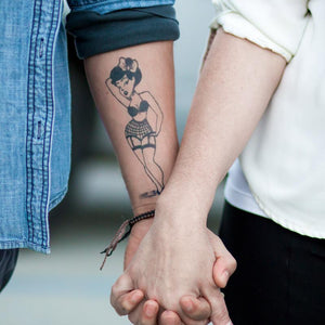 Pinup girl temporary jagua tattoo on couple holding hands.